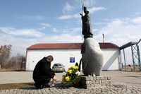 Kwiaty pod pomnikiem i tablicą Jana Pawła II